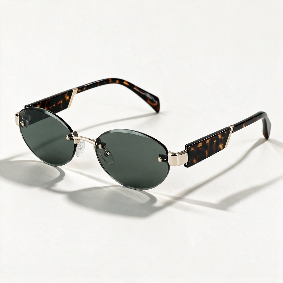 The Blank Tag Luna small rimless oval sunglasses for women, tortoise temples with deep green lens – front view — view 1